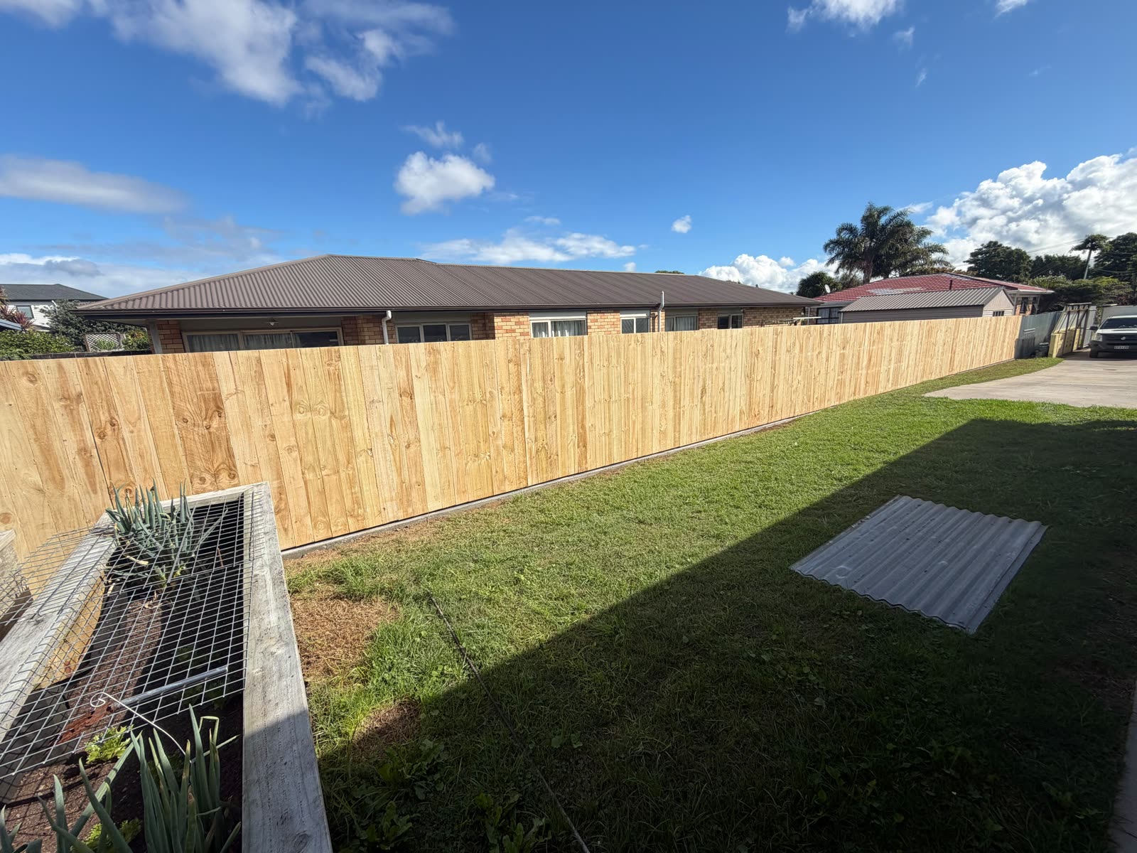 Straight-run timber boundary fence in Papakura tied into an existing corrugated fence