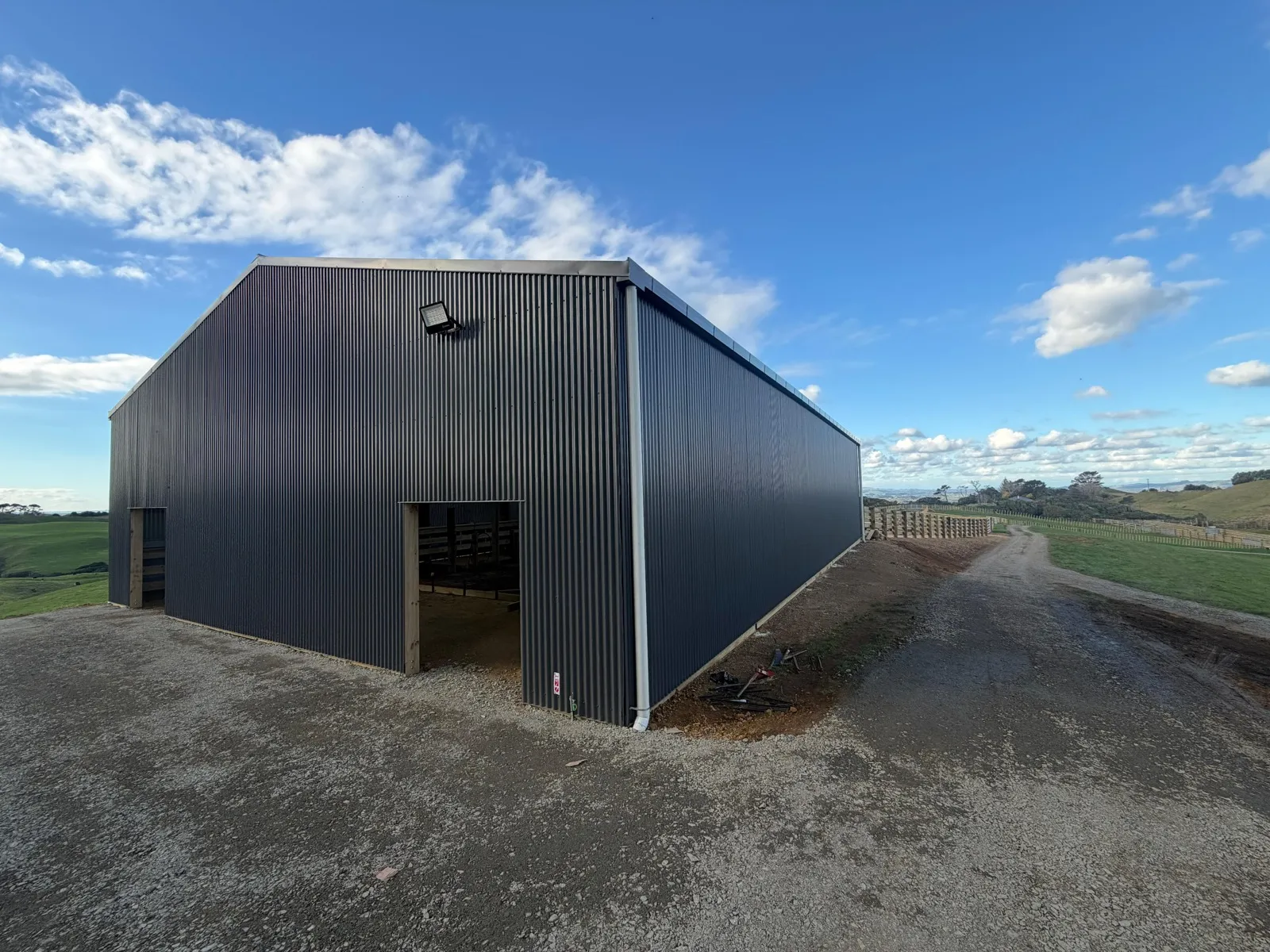 Finished pole shed clad in dark Colorsteel on a farm in Whiriwhiri, Waiuku